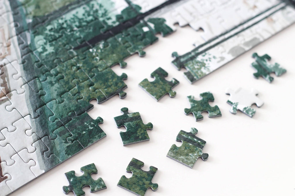 Art Gallery jigsaw puzzle edge pieces close up with green and white pieces spread.