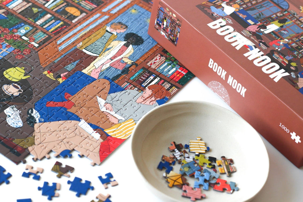 Book Nook jigsaw puzzle partially completed next to a puzzle box.