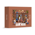 Book Nook 1000-piece jigsaw puzzle by Piecely, featuring a cozy library with people reading and a raccoon on a bookshelf. Ett mysigt pussel för vuxna med boktema.