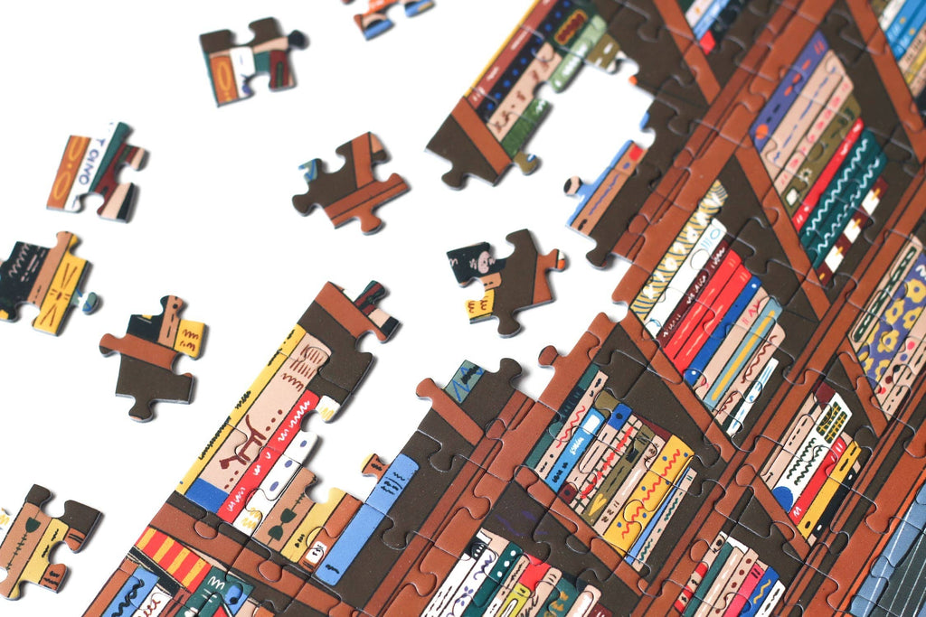 Book Nook jigsaw puzzle close up on the edge with pieces spread.