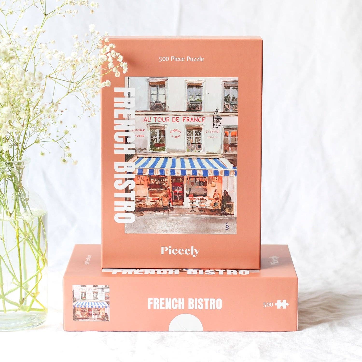 French Bistro jigsaw puzzle boxes stacked and displayed on a clear background.