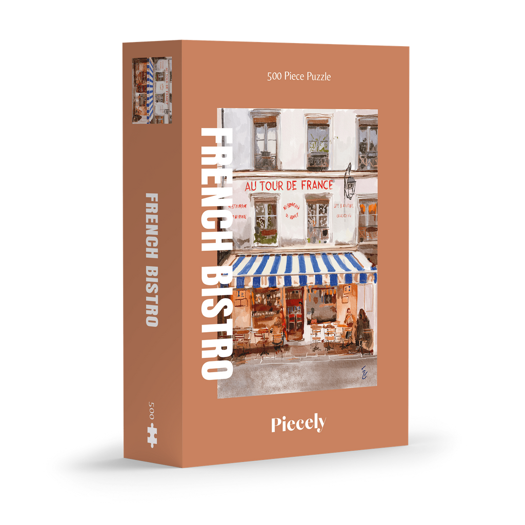 French Bistro 500-piece jigsaw puzzle by Piecely, featuring a street scene with a cozy restaurant and blue-and-white striped awnings. Ett charmigt pussel för vuxna med stadsmotiv.