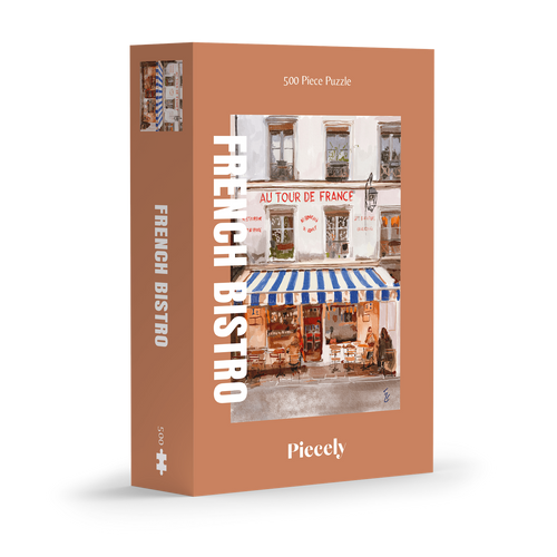 French Bistro 500-piece jigsaw puzzle by Piecely, featuring a street scene with a cozy restaurant and blue-and-white striped awnings. Ett charmigt pussel för vuxna med stadsmotiv.