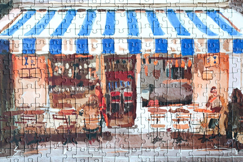 Partial puzzle of a street scene with people and tables under blue and white striped awnings.