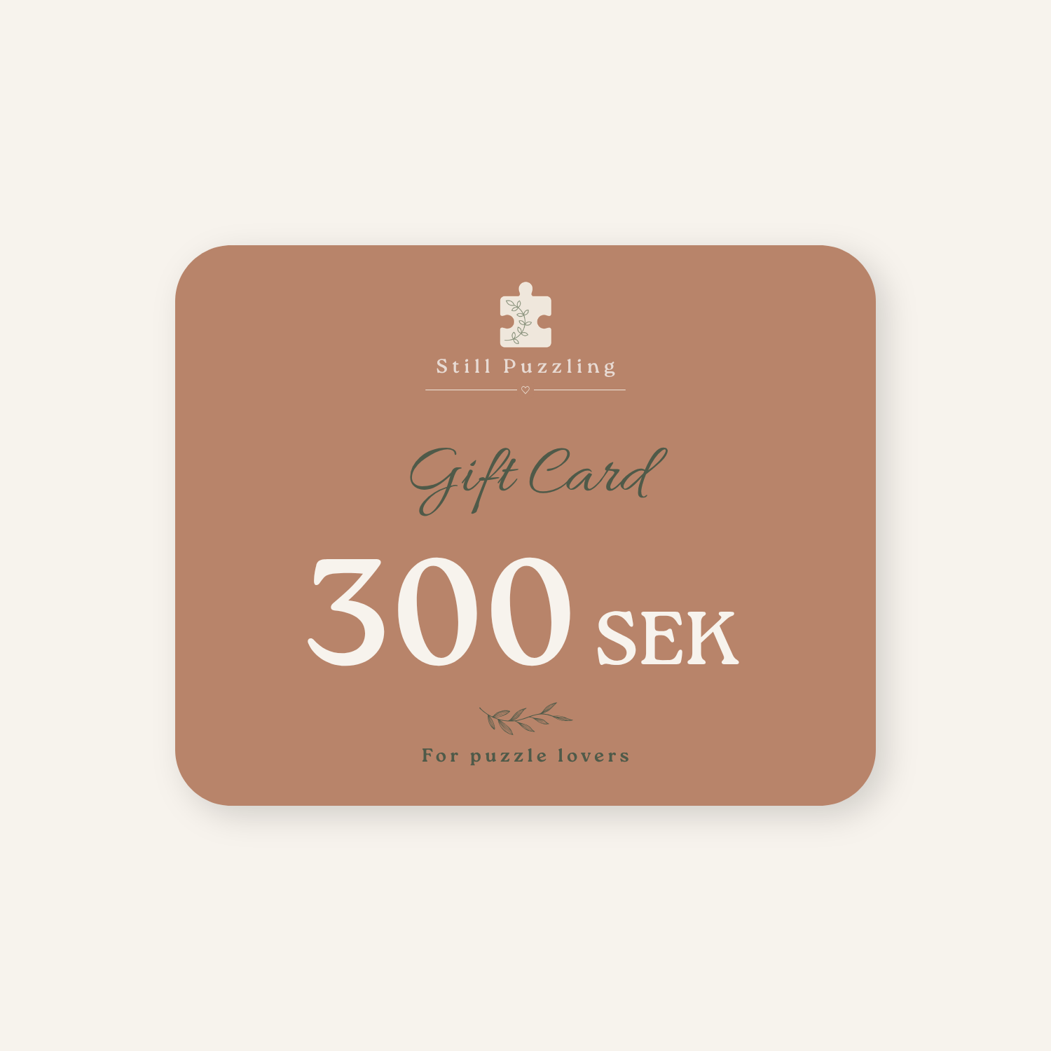 A rectangular gift card with rounded corners in a muted dusty rose color, featuring the text 'Stilli Puzzling', 'Gift Card', '300 SEK', and 'For puzzle lovers' in white and dark green lettering, centered on a light cream background.