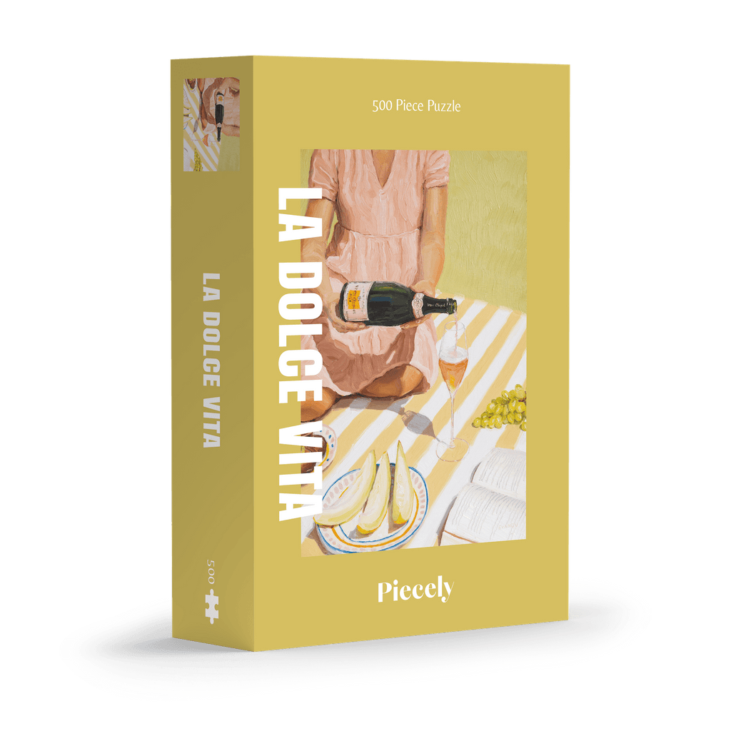 La Dolce Vita 500-piece jigsaw puzzle by Piecely, featuring a woman serving a drink at a picnic setting. Ett avkopplande pussel för vuxna.