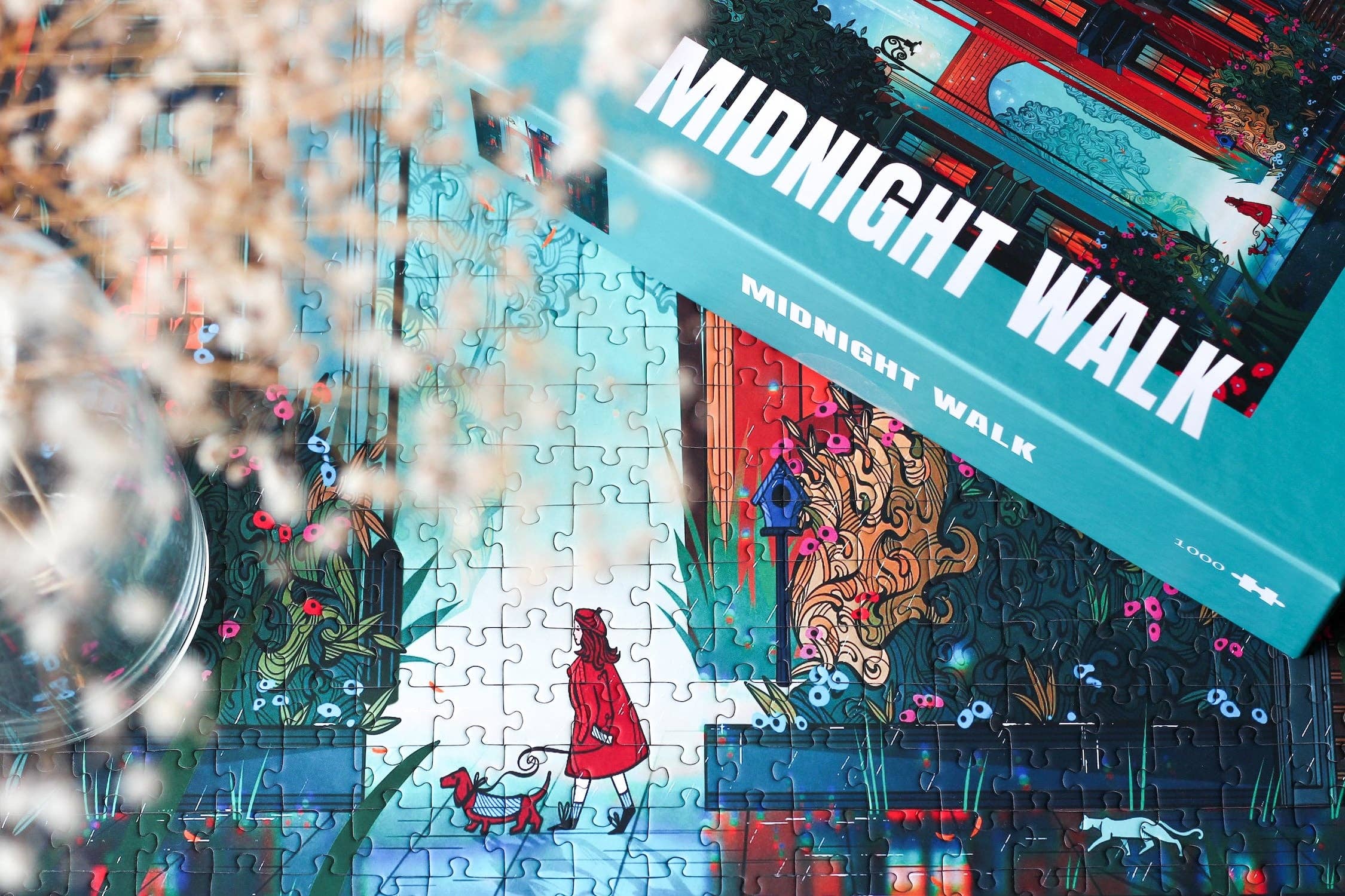 Midnight Walk jigsaw puzzle box next to a close up of the completed puzzle featuring a woman dressed in red walking her dog.