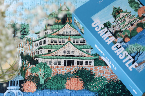 Osaka Castle jigsaw puzzle box next to a close up of the completed puzzle featuring a close up of the castle.