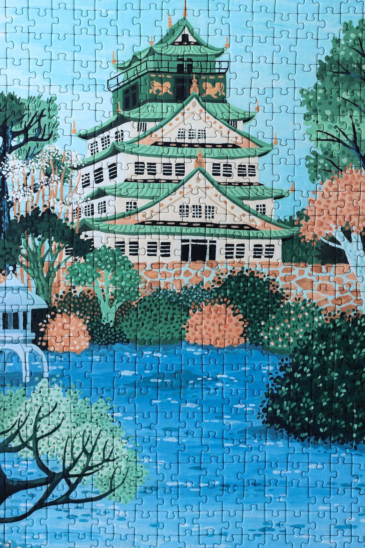 Osaka Castle jigsaw puzzle completed puzzle featuring the castle surrounded by water and plants.